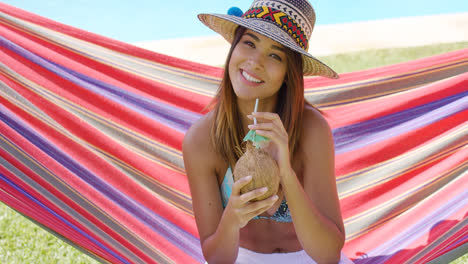 Woman-with-coconut-drink-and-sitting-in-hammock