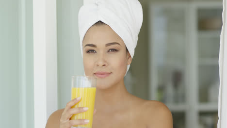 Smiling-healthy-young-woman-drinking-orange-juice