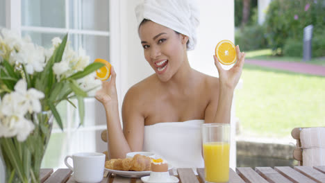Woman-wrapped-in-towel-holding-orange-slices