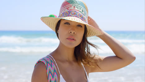 Smiling-young-woman-holding-her-sunhat