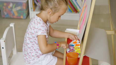 Adorable-little-girl-mixing-colorful-paints