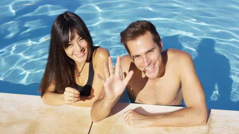 Smiling-couple-standing-in-clear-pool-wave