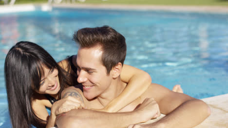 Smiling-man-with-tattoo-is-cuddled-by-girlfriend