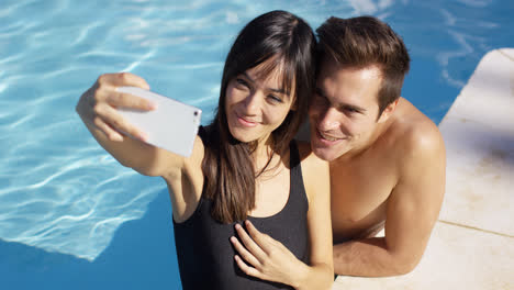 Handsome-couple-take-photo-while-standing-in-pool