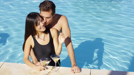 Loving-couple-smooching-at-swimming-pool