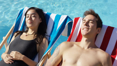 Contented-young-couple-smiling-as-they-sunbathe