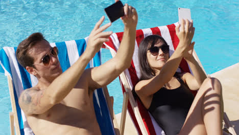 Man-and-woman-taking-self-portraits-at-pool