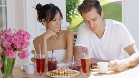 Attractive-couple-enjoying-breakfast-outdoors