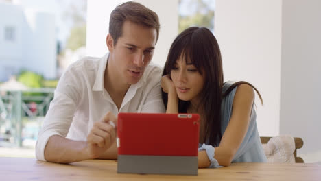 Smiling-couple-using-a-tablet-computer-together