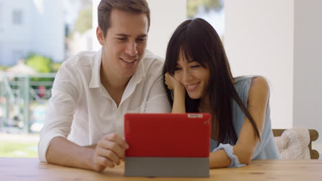 Smiling-couple-using-a-tablet-computer-together