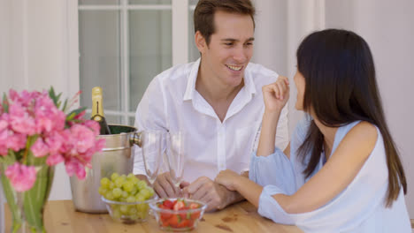 Cute-mixed-couple-enjoying-wine-and-fruit-together