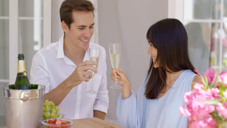 Junges-Glückliches-Erwachsenes-Paar,-Das-Champagner-Anstößt