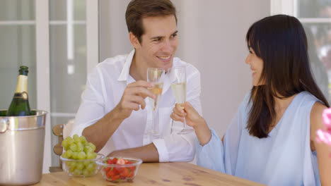Cheerful-couple-toasting-champagne