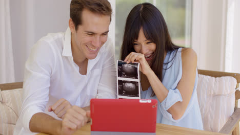 Blushing-couple-showing-off-ultrasound-pictures