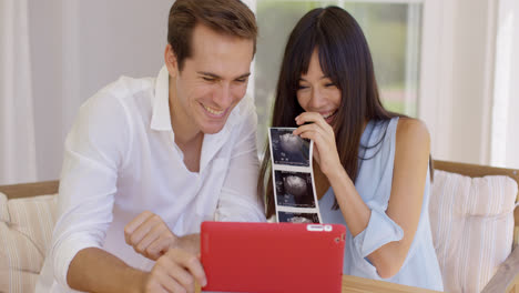 Blushing-couple-showing-off-ultrasound-pictures