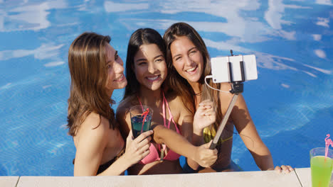Three-young-women-taking-a-selfie-in-the-pool
