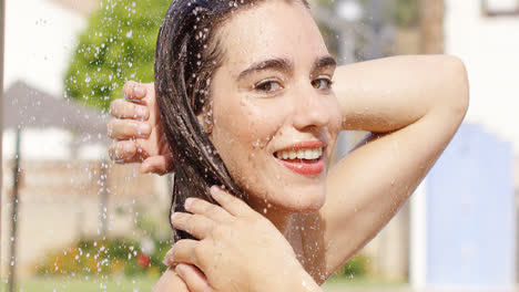 Beauty-smiles-at-camera-while-standing-in-shower