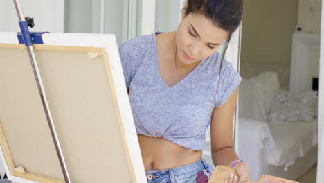 Mujer-Joven-Artística-Trabajando-En-Una-Pintura