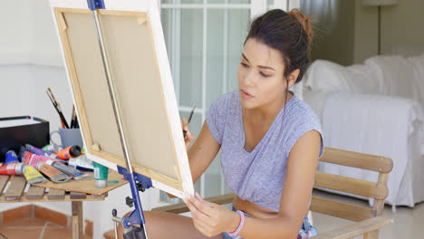 Attractive-female-artist-working-on-a-canvas