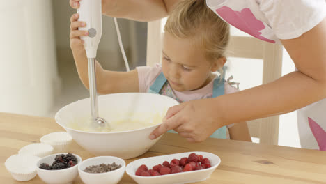Cute-little-girl-learning-to-bake-from-mother