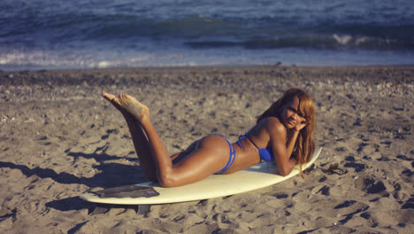 Chica-Sexy-Tumbada-En-Una-Tabla-De-Surf-En-La-Playa