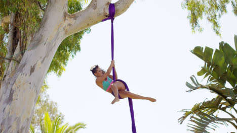 Gorgeous-young-woman-gymnast-working-out-on-silks