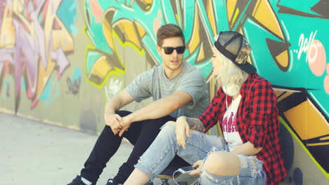 Trendiges-Junges-Hipster-Paar,-Das-Auf-Der-Straße-Sitzt