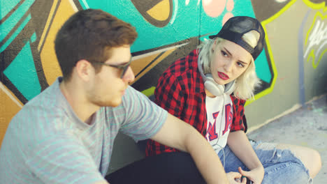 Young-hipster-urban-couple-relaxing-on-a-sidewalk