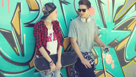 Trendy-young-skateboarders-standing-chatting