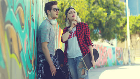 Young-trendy-urban-couple-standing-chatting