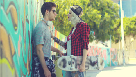 Trendy-young-couple-chatting-in-an-urban-street