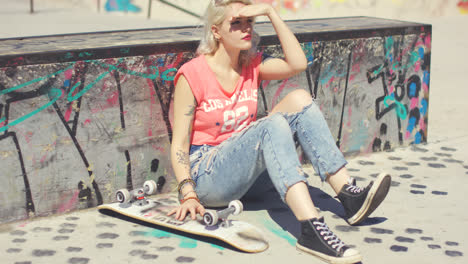 Young-woman-waiting-at-a-skate-park-for-a-friend