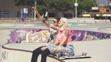 Happy-trendy-young-couple-waving-at-someone