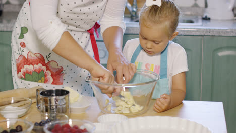 Mother-teaching-her-small-daughter-to-bake