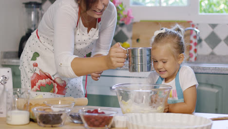 Cute-little-girl-helping-her-mother-bake-a-tart