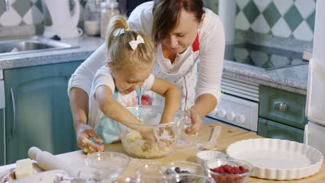 Little-girl-helping-to-knead-the-pastry-dough