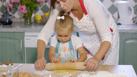 Mother-rolling-out-pastry-with-a-little-helper