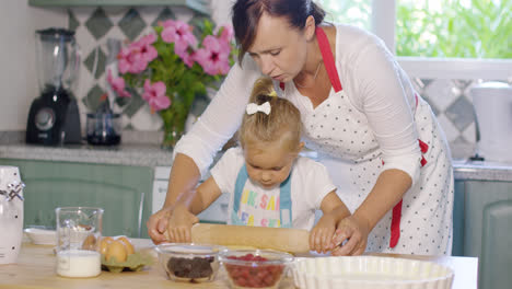 Mother-rolling-out-pastry-with-a-little-helper