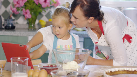Mother-and-daughter-checking-a-baking-recipe