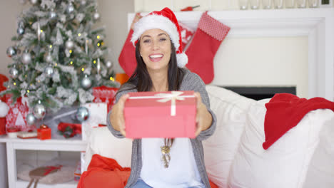 Laughing-woman-offering-a-large-Christmas-gift