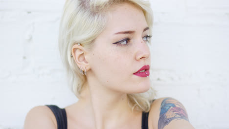Pensive-hipster-woman-with-a-piercing-and-tattoo
