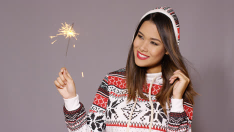 Young-woman-celebrating-Christmas-with-a-sparkler