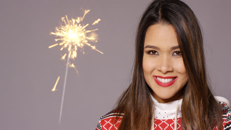 Young-woman-celebrating-Christmas-with-a-sparkler