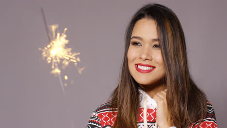Attractive-young-woman-celebrating-with-a-sparkler