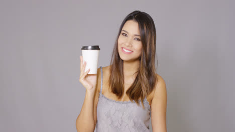 Young-woman-offering-a-cup-of-takeaway-coffee