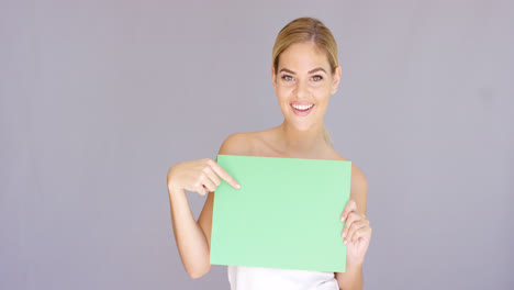 Attractive-blond-woman-holding-a-blank-green-sign