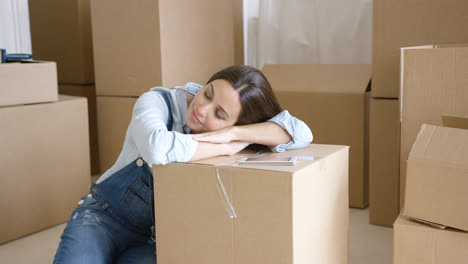 Young-woman-taking-a-nap-on-a-brown-carton