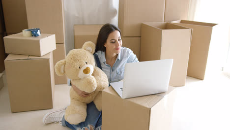 Young-woman-moving-house-with-her-teddy-bear