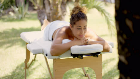 Calm-woman-relaxing-on-massage-table-outside