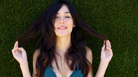 Pretty-woman-with-long-brown-hair-lays-in-grass